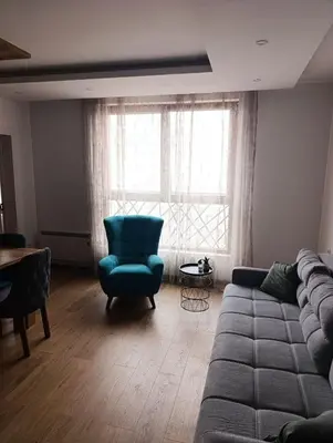 a living room with a couch and a chair and a window at Kopaonik-President kop apartment 101 free wellness&spa in Kopaonik