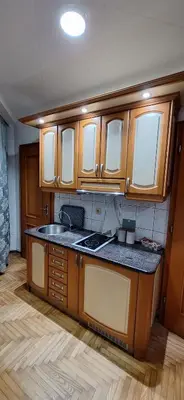 a kitchen with wooden cabinets and a sink at Apricus Mini Apartman Vrnjacka banja in Vrnjačka Banja