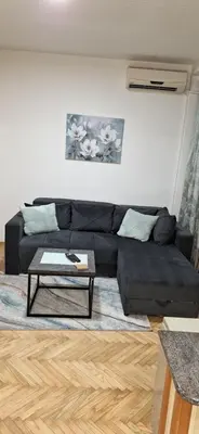a living room with a black couch and a coffee table at Apricus Mini Apartman Vrnjacka banja in Vrnjačka Banja