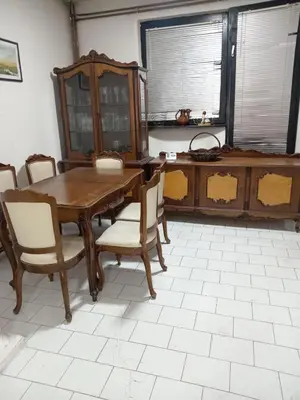 a dining room with a wooden table and chairs at Mića Alas vikendica in Orljane