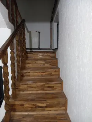 a stairway with wooden steps and a white wall at Mića Alas vikendica in Orljane