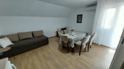 a living room with a couch and a table with chairs at Orhideja smeštaj Sokobanja in Lepterija