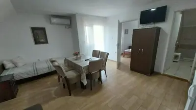 a living room with a table and chairs and a couch at Orhideja smeštaj Sokobanja in Lepterija