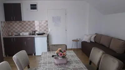 a living room with a table and a couch at Orhideja smeštaj Sokobanja in Lepterija