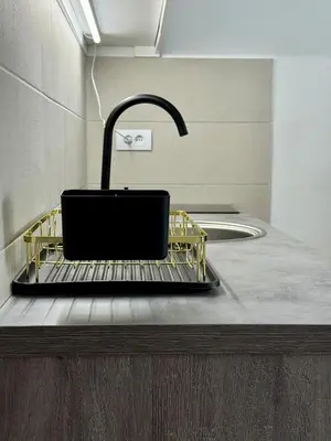a kitchen counter with a sink and a black sinkiterator at Royal Apartmani 2 in Paraćin