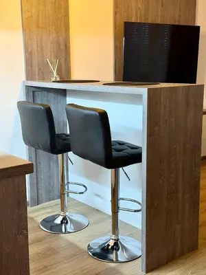 two black bar stools sitting at a counter at Royal Apartmani 2 in Paraćin