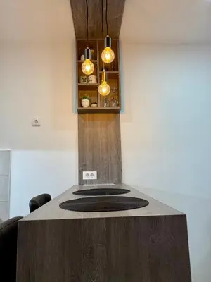 a kitchen with a wooden counter top with lights at Royal Apartmani 1 in Paraćin
