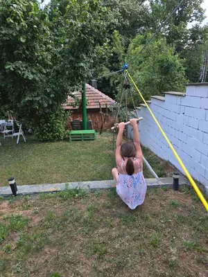 a little girl is playing on a swing at Seosko domaćinstvo Trajković