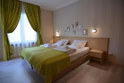 a bedroom with a bed with a green blanket and a window at Cvetni konaci-Lenka in Vrnjačka Banja