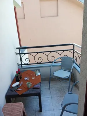 a table and a chair on a balcony at Cvetni konaci-Lenka in Vrnjačka Banja