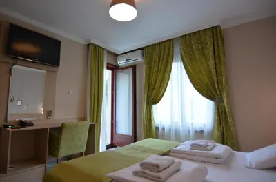 a hotel room with a bed and a window at Cvetni konaci-Lenka in Vrnjačka Banja
