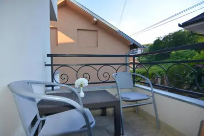 two chairs and a table on a balcony at Cvetni konaci-Lenka in Vrnjačka Banja