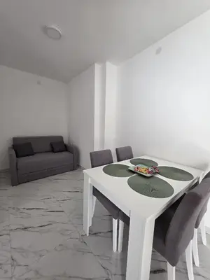 a white dining room with a white table and chairs at Studio IV in Soko Banja