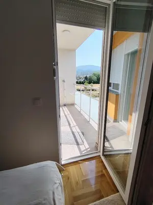 a bedroom with a bed and a large sliding glass door at Apartman Fenix in Pirot