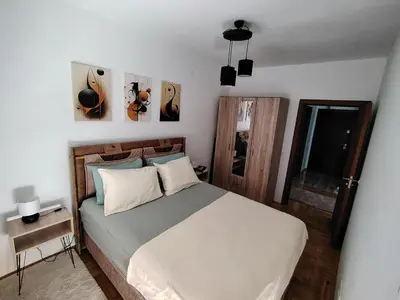 a bedroom with a large bed with white sheets at Apartman Fenix in Pirot