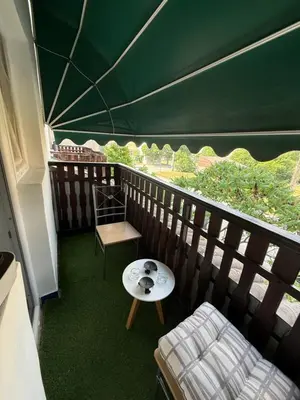 a balcony with a table and a green tent at Stan na dan Despotovac in Despotovac