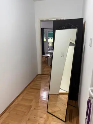 a mirror in a room with a wooden floor at Stan na dan Despotovac in Despotovac