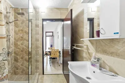 a bathroom with a sink and a glass shower at Apartmani Sokobanja Alexandar in Soko Banja