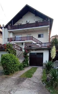 a white house with a garage and a driveway at Apartmani Sokobanja Alexandar in Soko Banja
