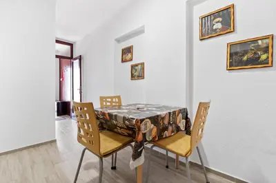 a dining room with a table with chairs and paintings at Apartmani Sokobanja Alexandar in Soko Banja
