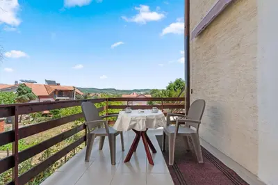 a table and chairs on a balcony with a view at Apartmani Sokobanja Alexandar in Soko Banja