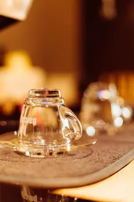 a glass teapot on a plate on a table at Grey Nest - Luxury Studio Apartment in Planet Residence, Niš in Niš