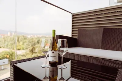 a bottle of wine and two glasses on a table at Grey Nest - Luxury Studio Apartment in Planet Residence, Niš in Niš
