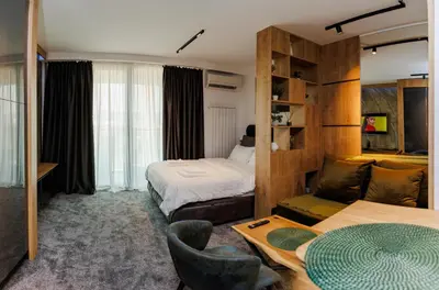 a hotel room with two beds and a couch at Grey Nest - Luxury Studio Apartment in Planet Residence, Niš in Niš