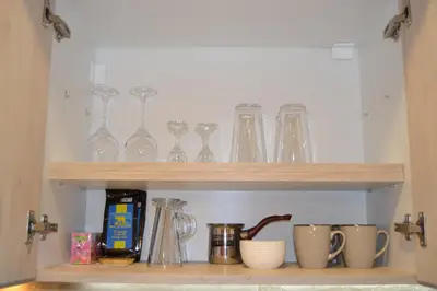 a shelf with glasses and other items on it at Star Apartman in Vranje