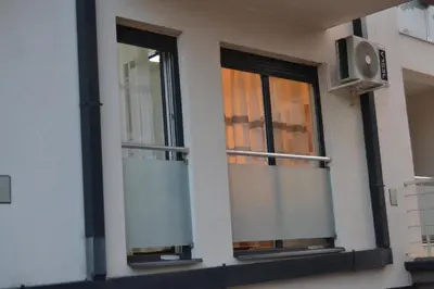 two windows on the side of a building with a tv at Star Apartman in Vranje