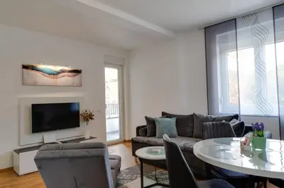 a living room with a couch and a table at Lemona Apartmani Vrnjačka Banja in Vrnjci