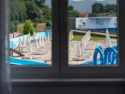 a view of a swimming pool through a window at Lemona Apartmani Vrnjačka Banja in Vrnjci
