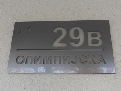 a sign on a wall with the number on it at Lemona Apartmani Vrnjačka Banja in Vrnjci