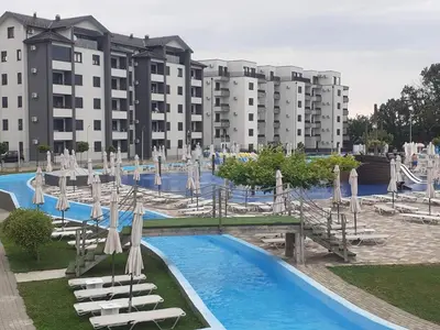 a resort with a water park with chairs and slides at Lemona Apartmani Vrnjačka Banja in Vrnjci