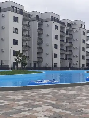 a swimming pool in front of a building at Lemona Apartmani Vrnjačka Banja in Vrnjci