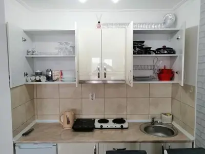 a kitchen with white cabinets and a sink at Studio-apartman DM lux in Vrnjačka Banja