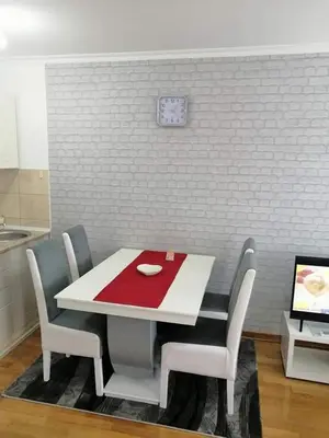 a white table with chairs and a red napkin on it at Studio-apartman DM lux in Vrnjačka Banja