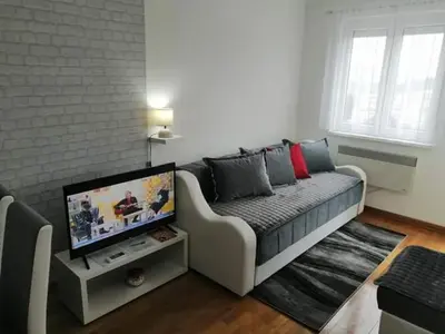 a living room with a couch and a flat screen tv at Studio-apartman DM lux in Vrnjačka Banja