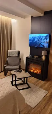 a living room with a fireplace and a flat screen tv at Sweet dreams apartman in Kopaonik