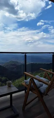a balcony with a bench and a table and a view at Sweet dreams apartman in Kopaonik