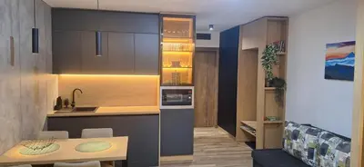 a small kitchen with a table and a counter top at Sweet dreams apartman in Kopaonik