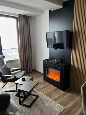 a living room with a fireplace and a television at Sweet dreams apartman in Kopaonik
