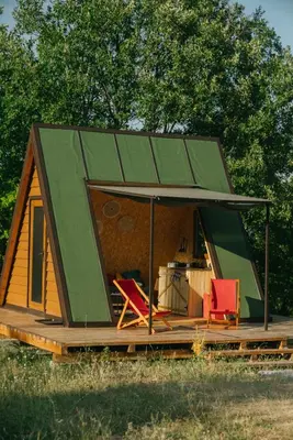 a tiny house with a green roof and two chairs at Sve Mir in Boljevac