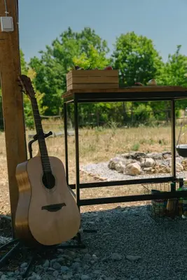 a guitar sitting on a stand next to a table at Sve Mir in Boljevac