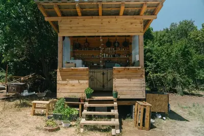 a wooden kiosk with a bar in a field at Sve Mir in Boljevac