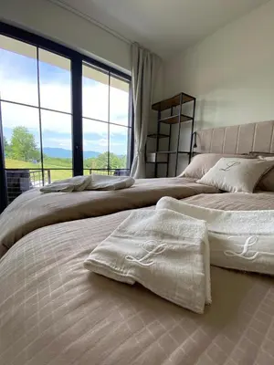 a bedroom with two beds and a large window at LaLuna Houses in Lipova