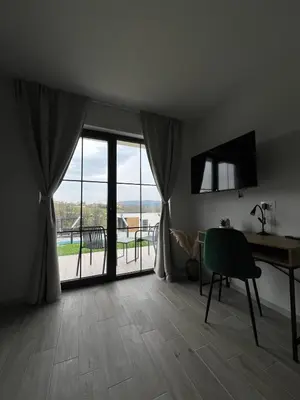 a room with a table and a desk and a window at LaLuna Houses in Lipova