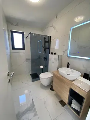 a white bathroom with a sink and a toilet at LaLuna Houses in Lipova