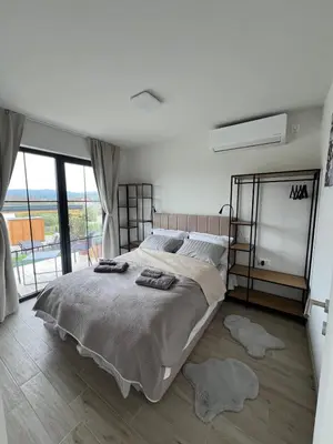 a bedroom with a large bed and a large window at LaLuna Houses in Lipova