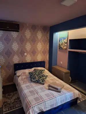 a bedroom with a bed with a plaid bedspread at Dolce Vita in Bukorovac